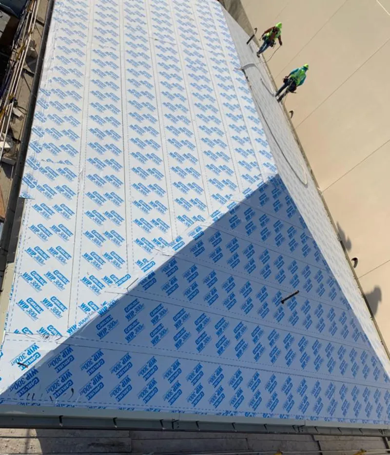 Professional roofers installing underlayment on a metal roof in New Brighton